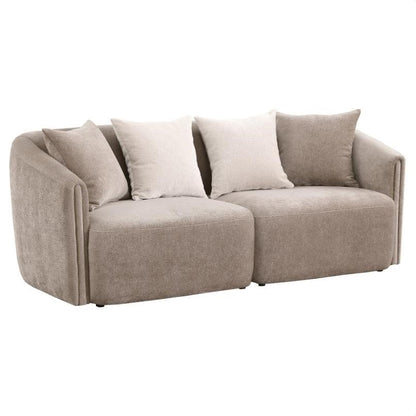 Beige sofa from the back with curved edges and multiple cushions.