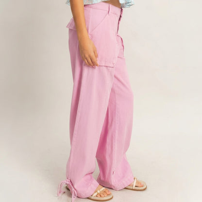 Person wearing wide-leg pink pants with sandals on a neutral background.