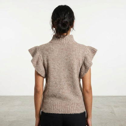 Person in a knitted sweater with ruffled sleeves, facing away.