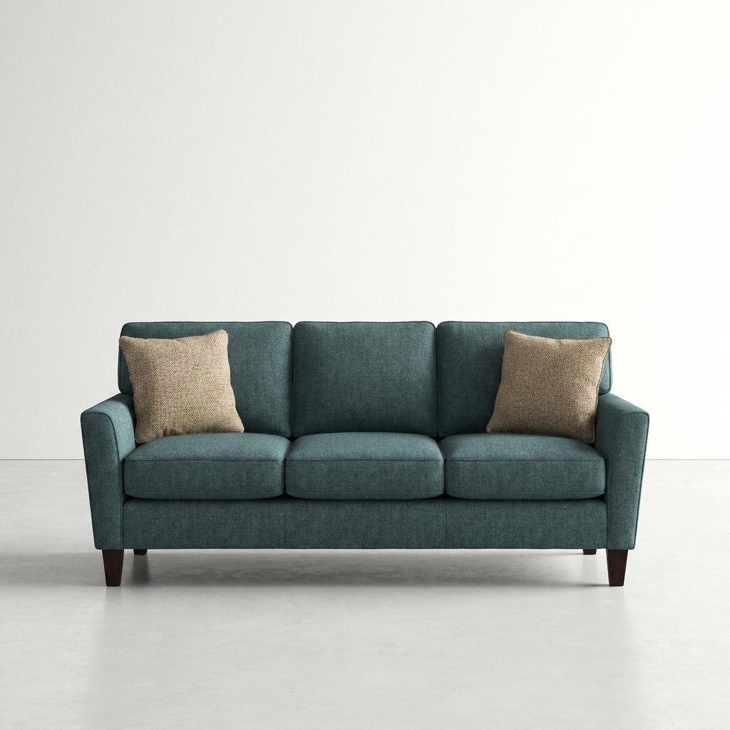 Teal sofa with beige pillows on a white background.
