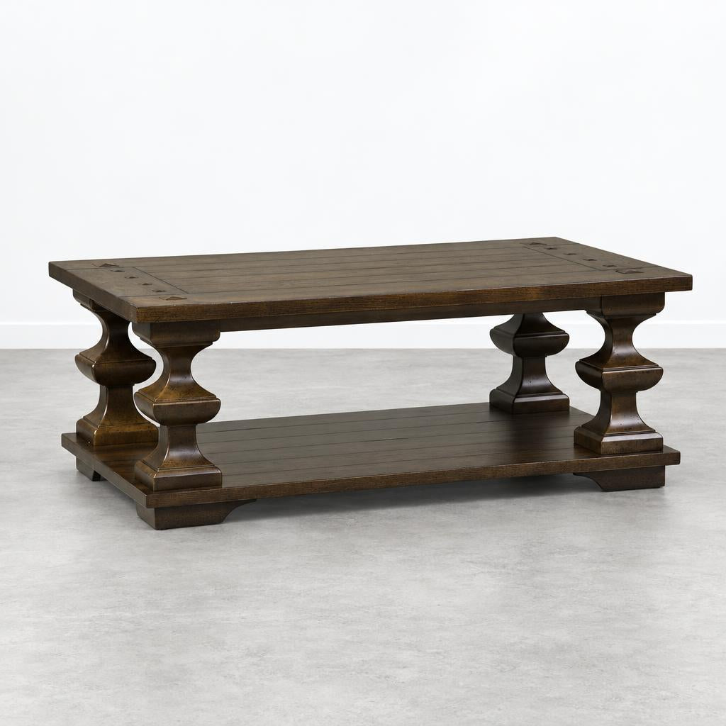 A dark wooden coffee table with ornate pedestal legs and a lower shelf.