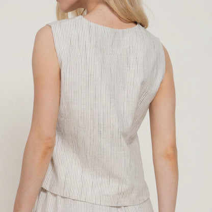 Woman in a sleeveless, striped top, facing backward.