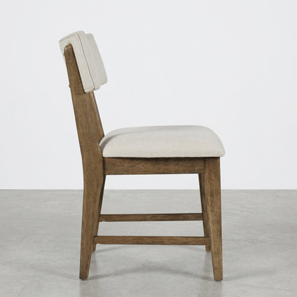 Wooden chair with beige cushion, side view.