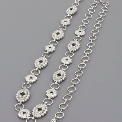Silver chain belts with ornate, linked medallion designs on a gray background.