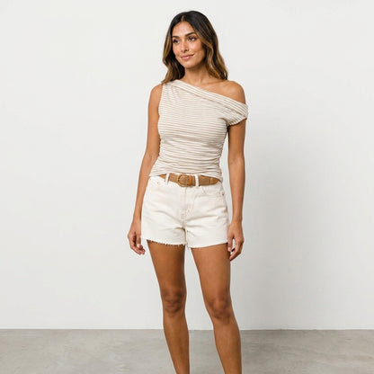 Woman in striped off-shoulder top and shorts against white background.