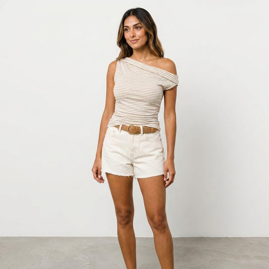 Woman in striped off-shoulder top and shorts against white background.