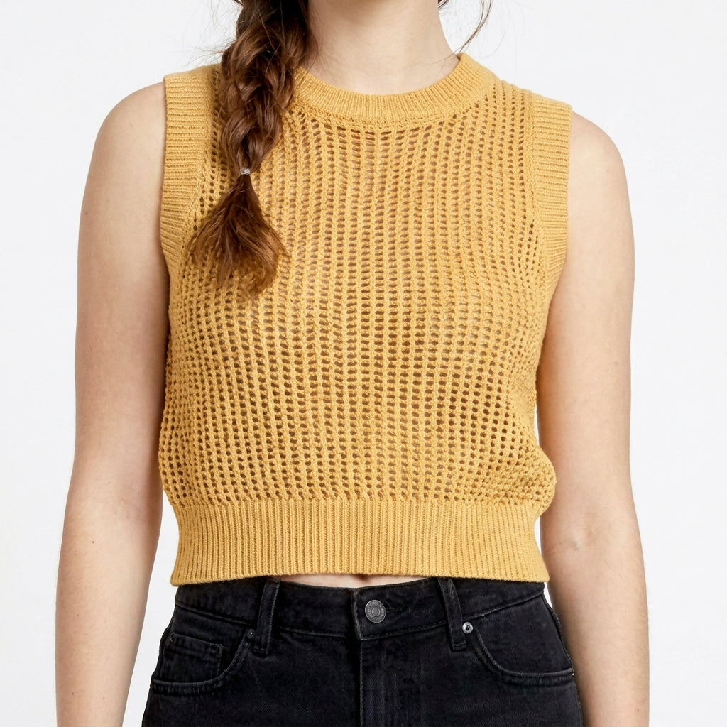 Woman in yellow crochet top and black jeans.