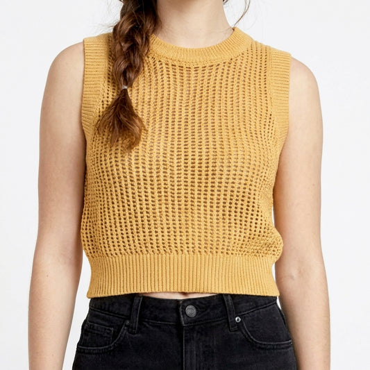 Woman in yellow crochet top and black jeans.