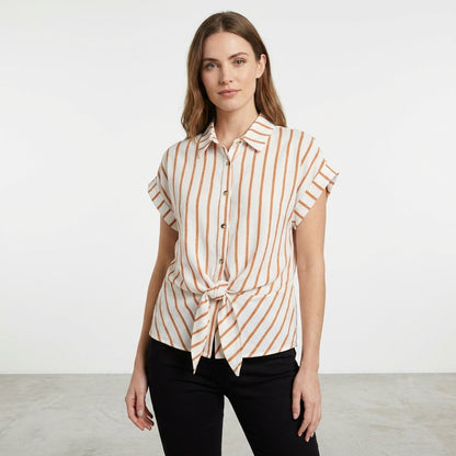 Woman in a striped shirt and black pants standing.