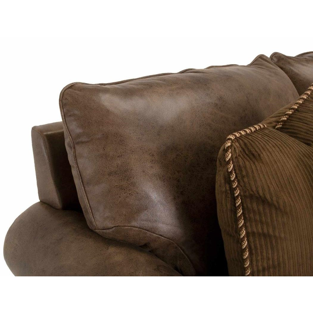 Brown leather sofa with textured fabric pillows.