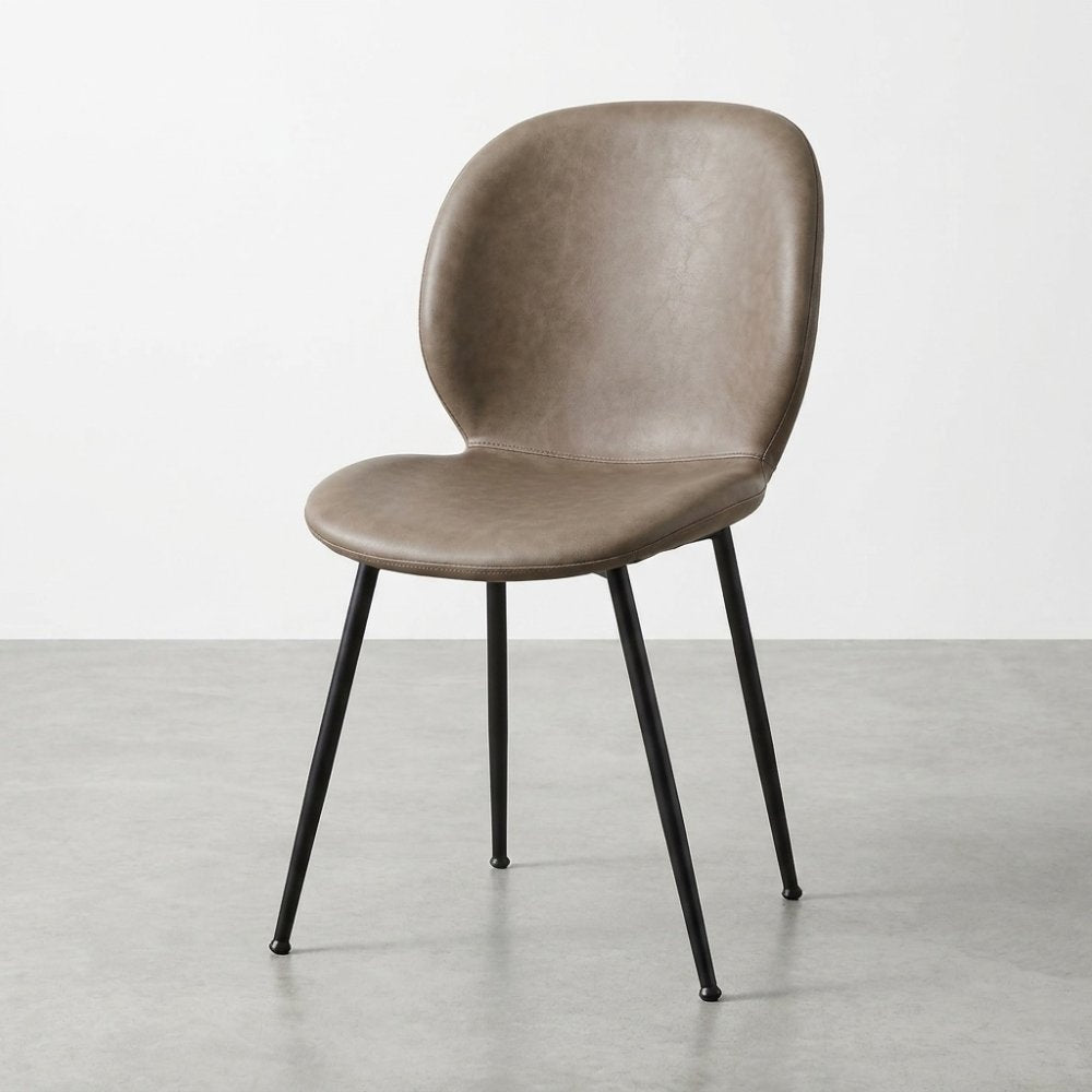 Modern brown chair with black metal legs on a concrete floor.