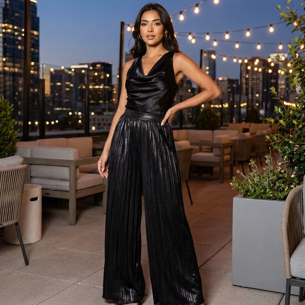 A woman in a black outfit poses on a rooftop patio lit by string lights at dusk.
