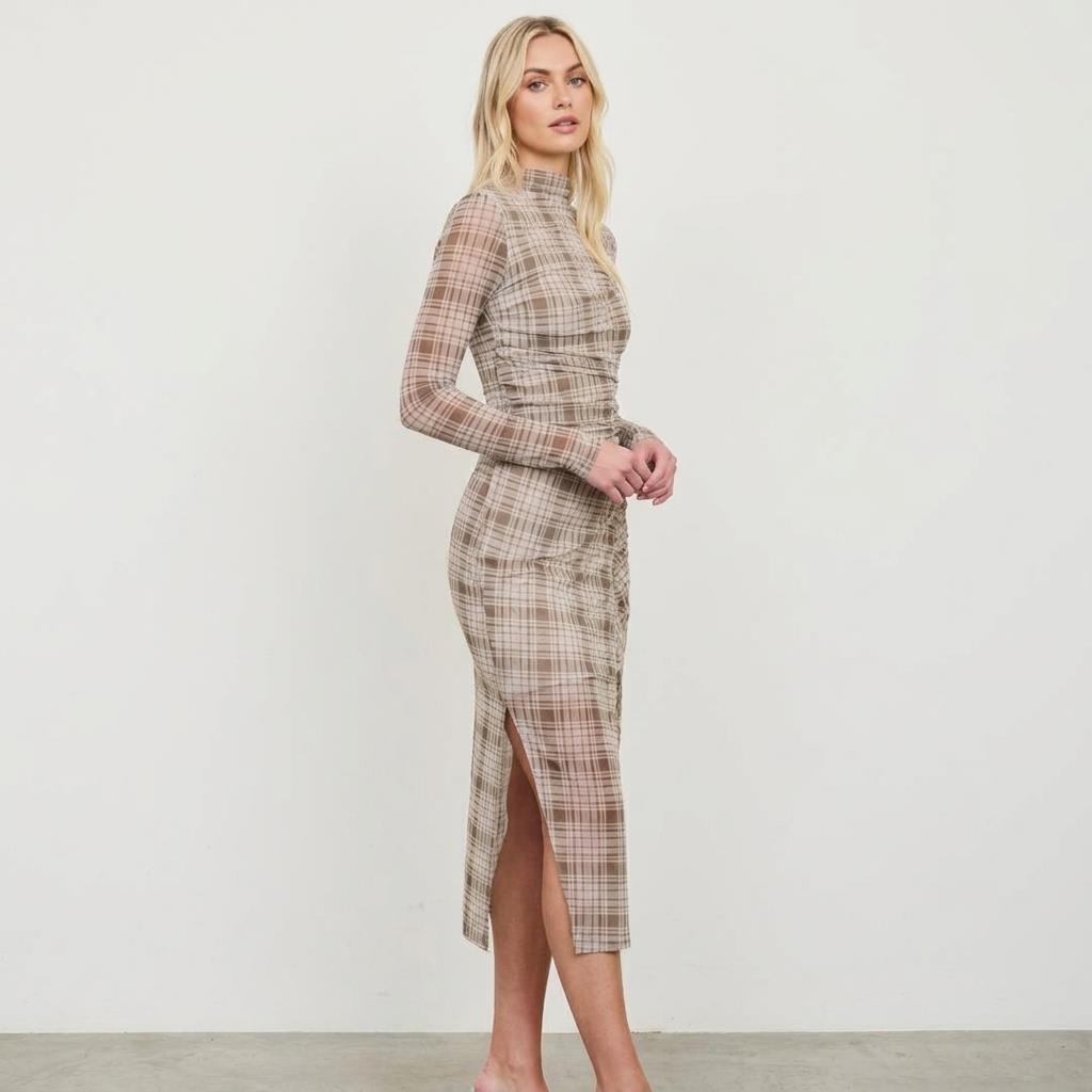 Person in a plaid dress poses against a plain white background.