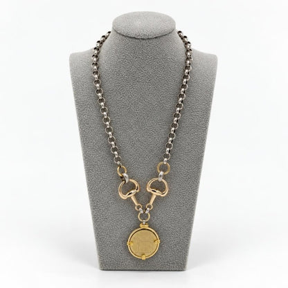 Two-tone silver and gold chain necklace with a round coin pendant displayed on a gray bust.