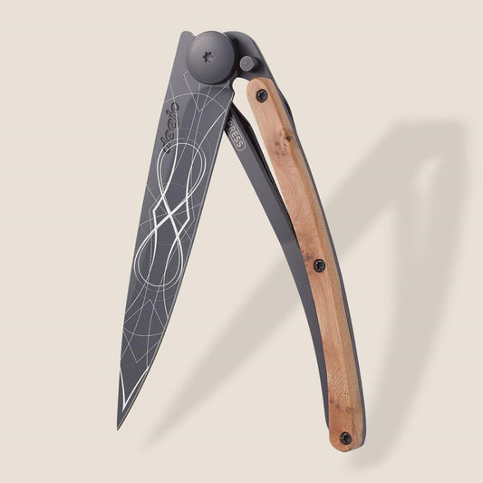 Folding knife with geometric blade pattern and wooden handle.