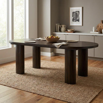 A dark wood dining table sits on a woven rug in a bright, minimalist room.