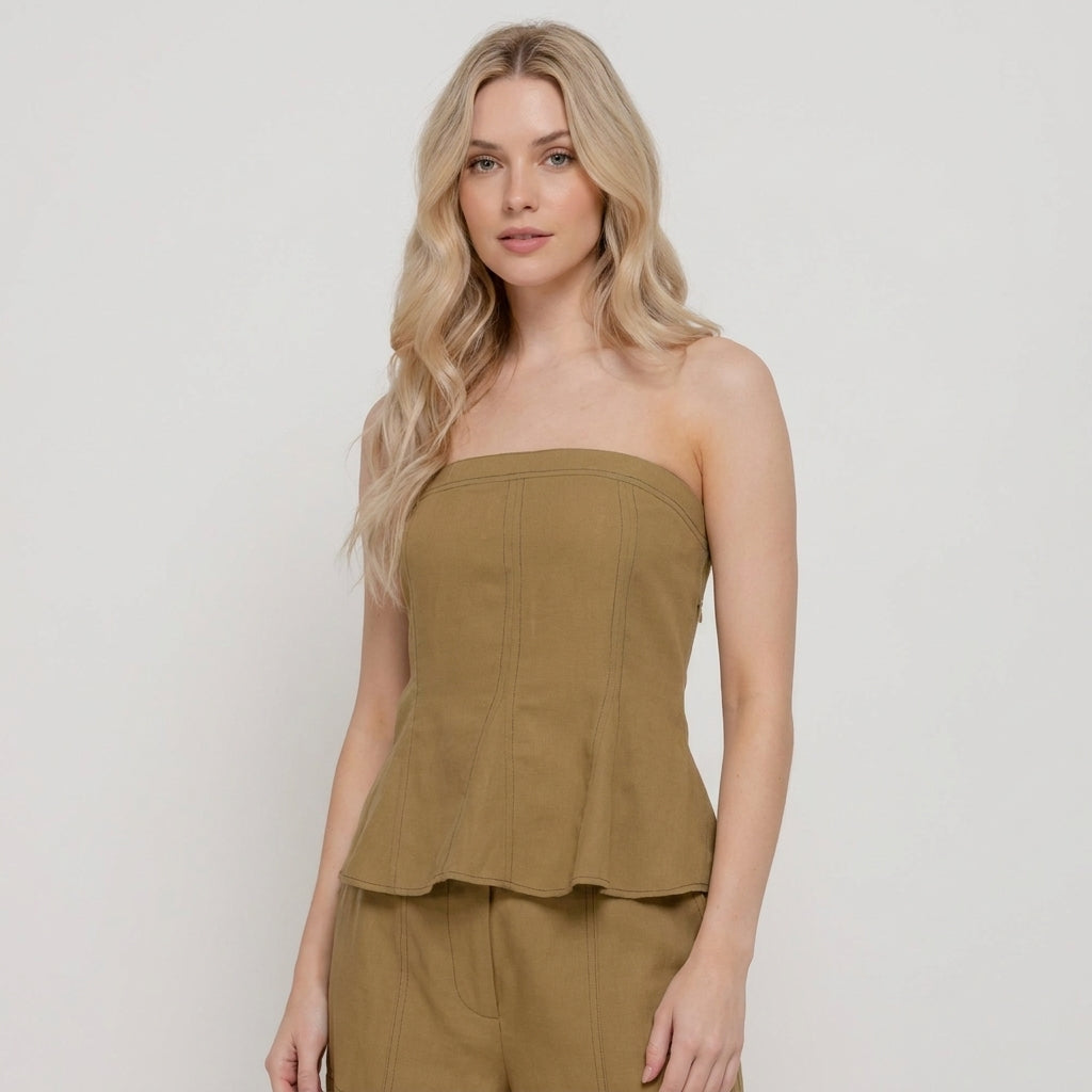 Woman in a strapless khaki top with flowing blonde hair.