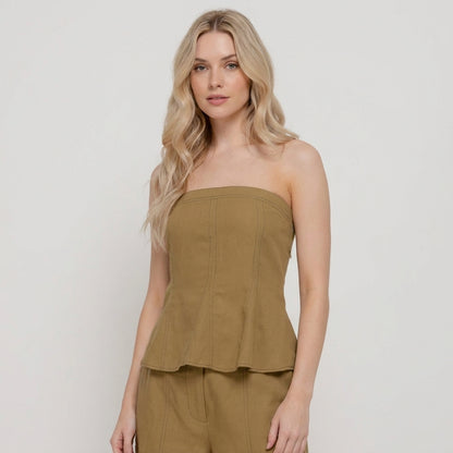 Woman in a strapless khaki top with flowing blonde hair.