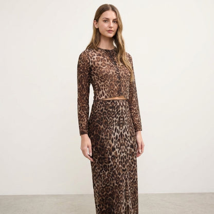 Woman in a leopard print dress standing against a blank background.