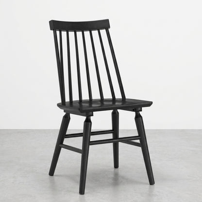 A black wooden chair with vertical slats, on a gray floor.