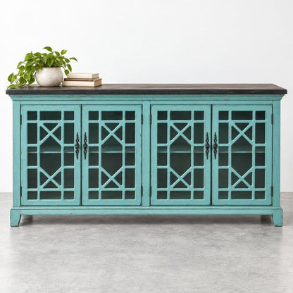 Turquoise cabinet with geometric glass doors, plant, and books on top.