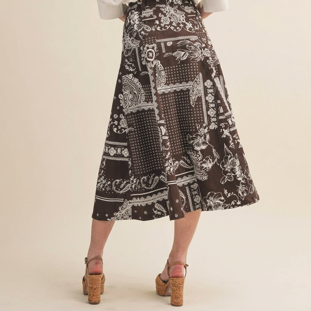 Brown patterned skirt, mid-length with floral designs, paired with heeled sandals.