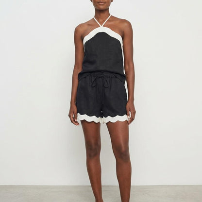 Woman in a black and white halter-neck romper.