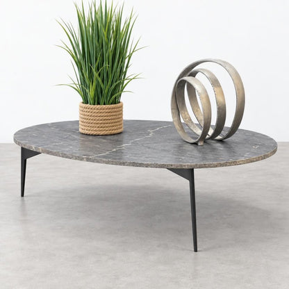 Marble table with a potted plant and metal sculpture.