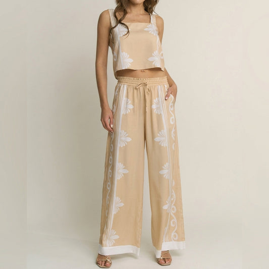Woman in beige floral two-piece outfit against a plain background.