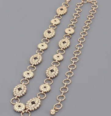 Gold-tone chain with ornate, oval links and decorative details.