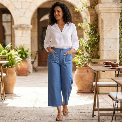 Woman in a casual outfit walking through a sunny courtyard.