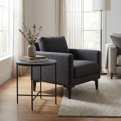 Cozy living room corner with gray armchair and side table.