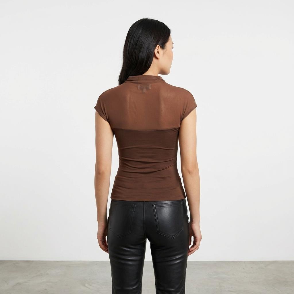 Woman in brown top and black pants, facing away.