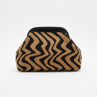 Brown and black wavy patterned sofa against white background.