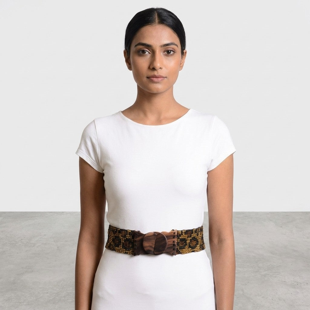 Woman in white dress with patterned belt, neutral background.