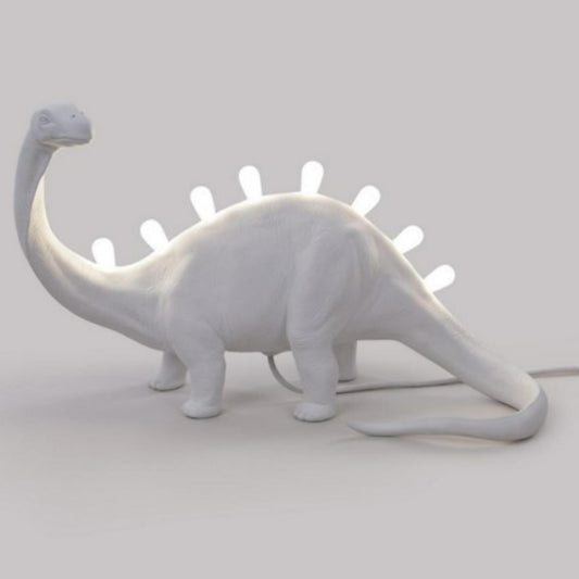 White dinosaur-shaped lamp with glowing spines.