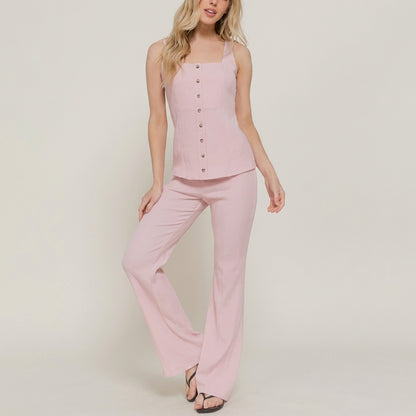 Woman in a pink button-up top and flared pants.
