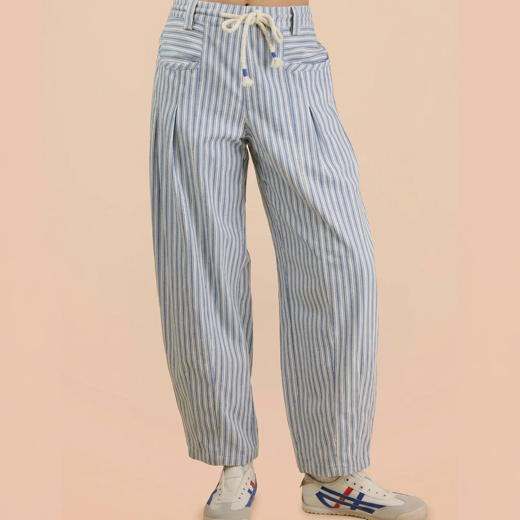 Striped pants and sneakers on a beige background.