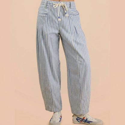 Striped pants and sneakers on a beige background.