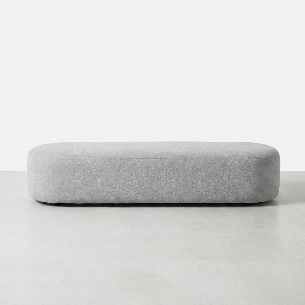 Long, rounded, light gray bench stool on a white background.