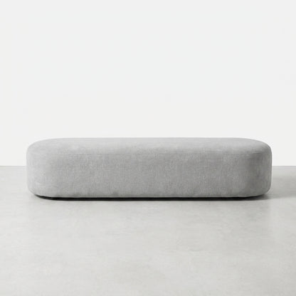 Long, rounded, light gray bench stool on a white background.