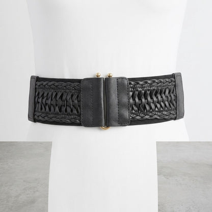 Black woven belt with golden clasp on white mannequin.