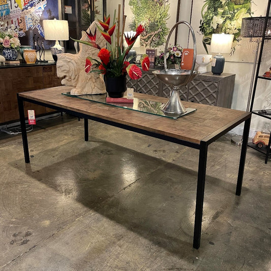Wooden table with floral centerpiece and decorative items in a showroom.