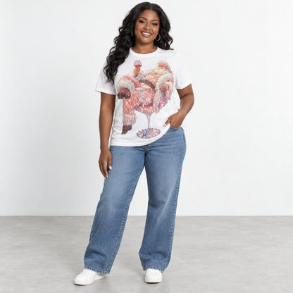 Smiling woman models a graphic white T-shirt, wide-leg jeans, and white sneakers.