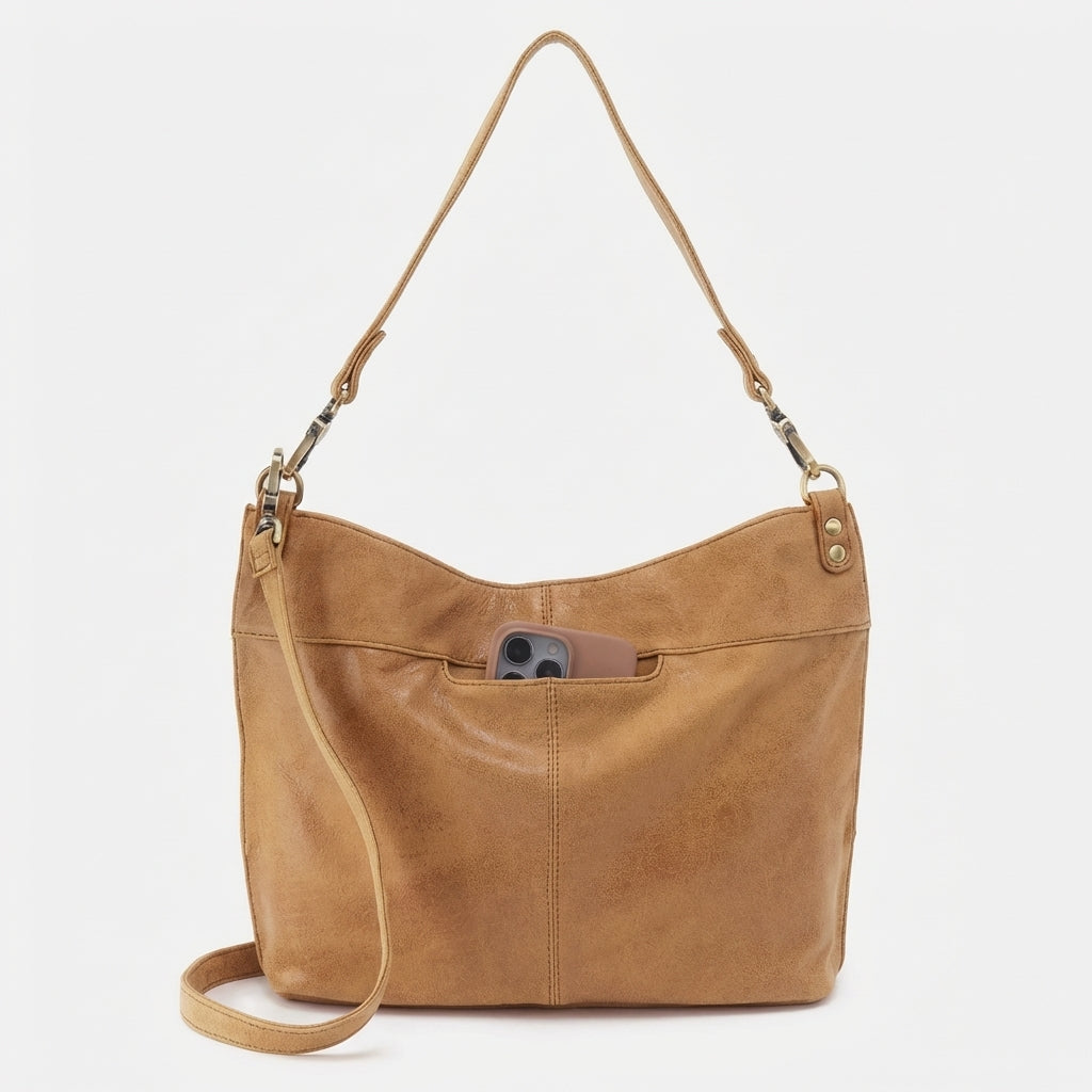 Tan leather bag with phone in outer pocket.