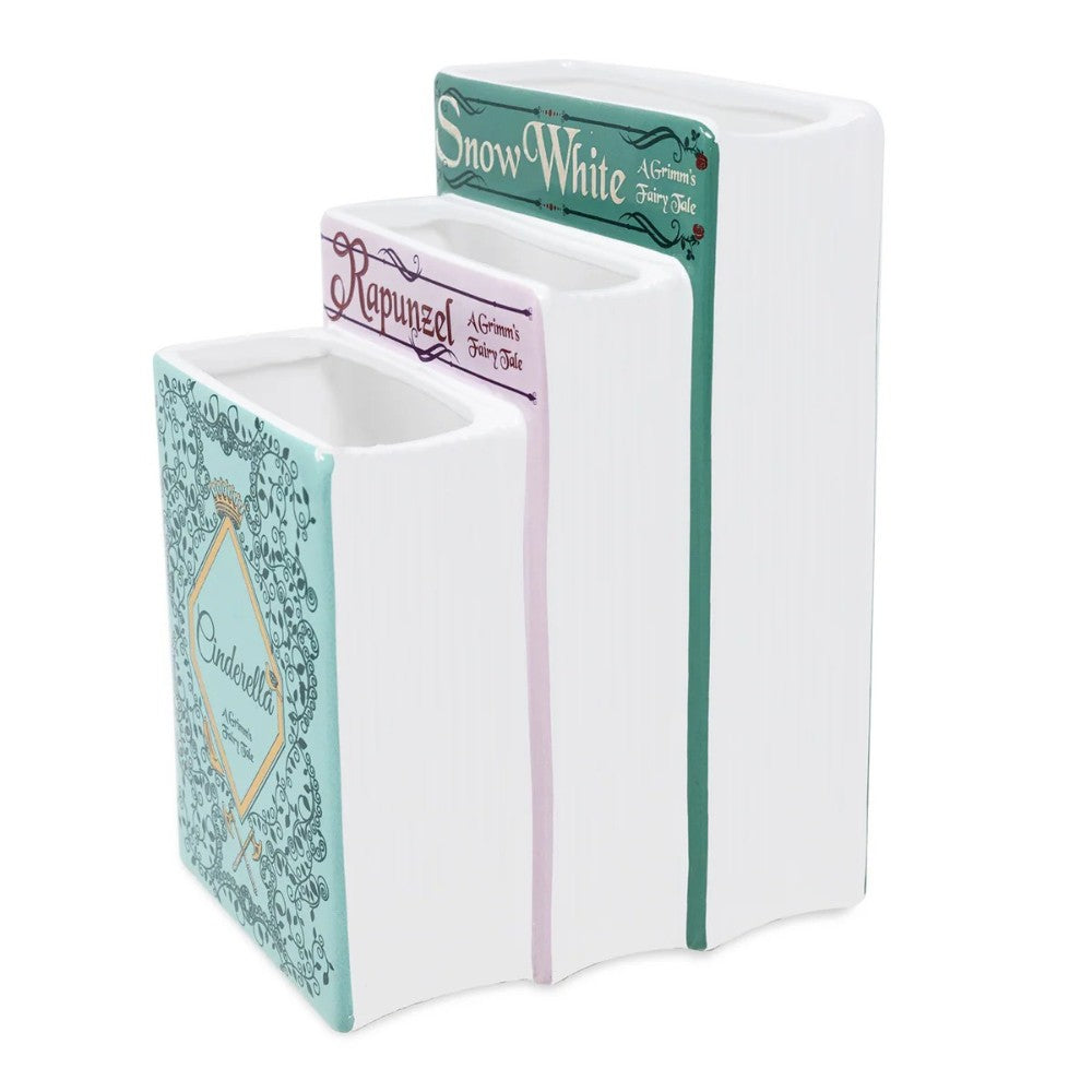Three book-shaped ceramic vases: Snow White, Rapunzel, Cinderella.