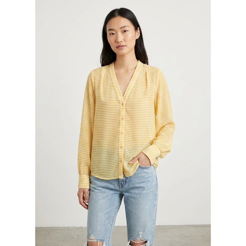 Person in a yellow striped shirt and jeans with hands in pockets.