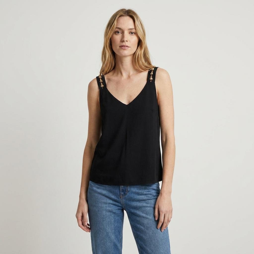 Person wearing a black sleeveless top and blue jeans against a plain background.