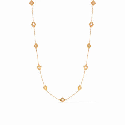 A delicate gold chain necklace featuring evenly spaced ornate clover-shaped charms.