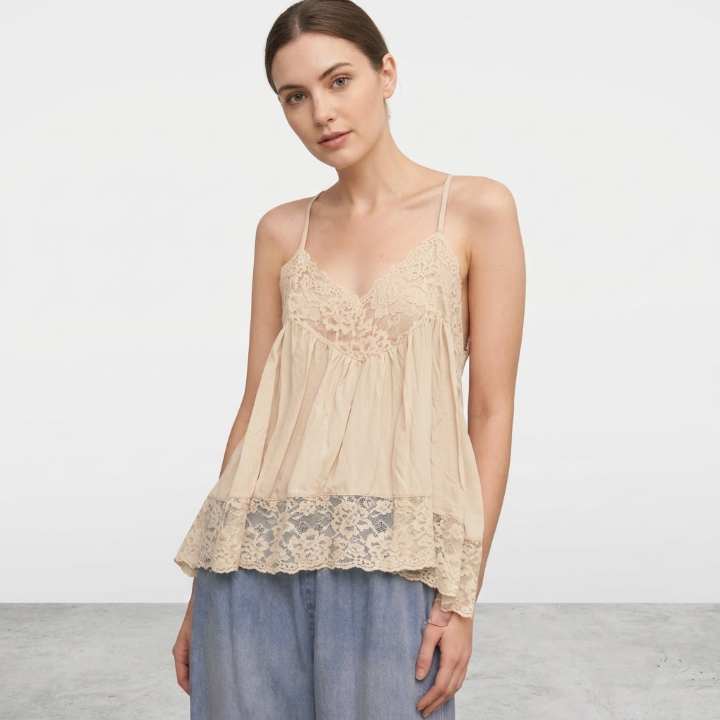 Woman in beige lace top with light blue jeans.